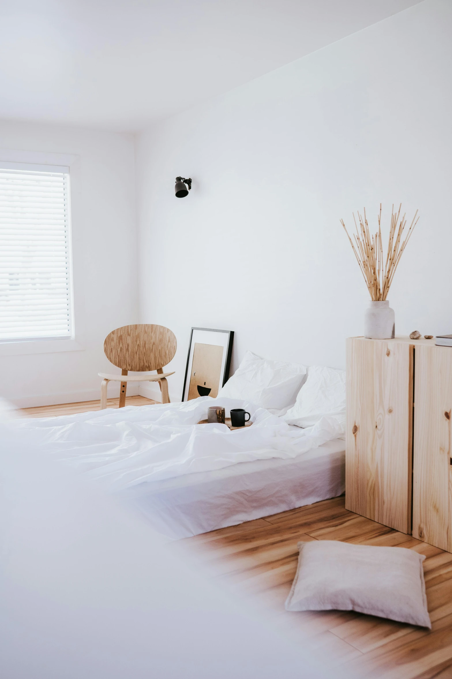 a wooden bed and white wall in a room