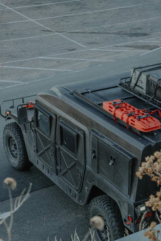 a military vehicle parked in a parking lot, a portrait, featured on reddit, red and black robotic parts, with a roof rack, high angle close up shot, firefighting gear