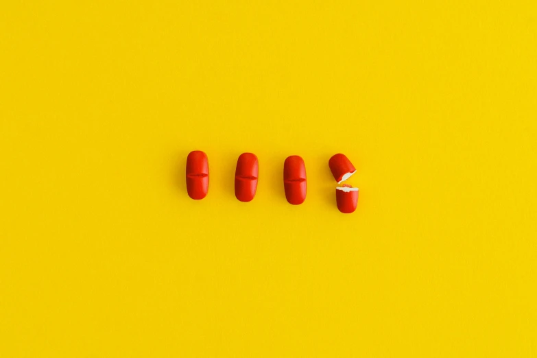 red pills arranged in a row on a yellow background, by Adam Marczyński, antipodeans, trending on dezeen, broken composition, red cap, 5