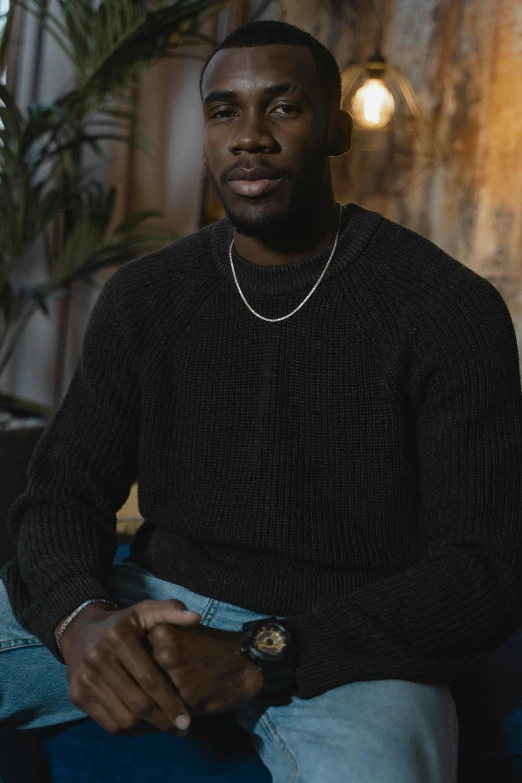 man sitting wearing a black sweater in a chair