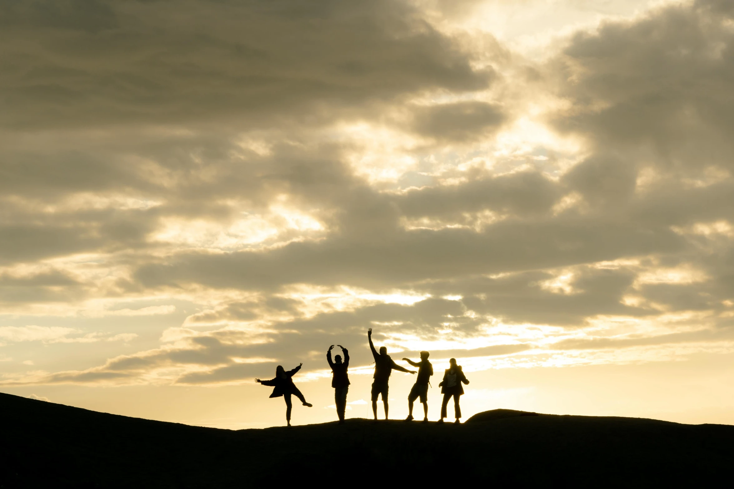 three silhouetted people with arms raised in the air