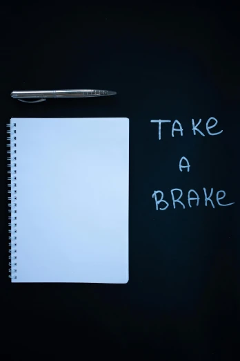 a notepad sitting on top of a desk next to a pen, by Bertram Brooker, graffiti, broken bones, thumbnail, take cover, left - hand drive