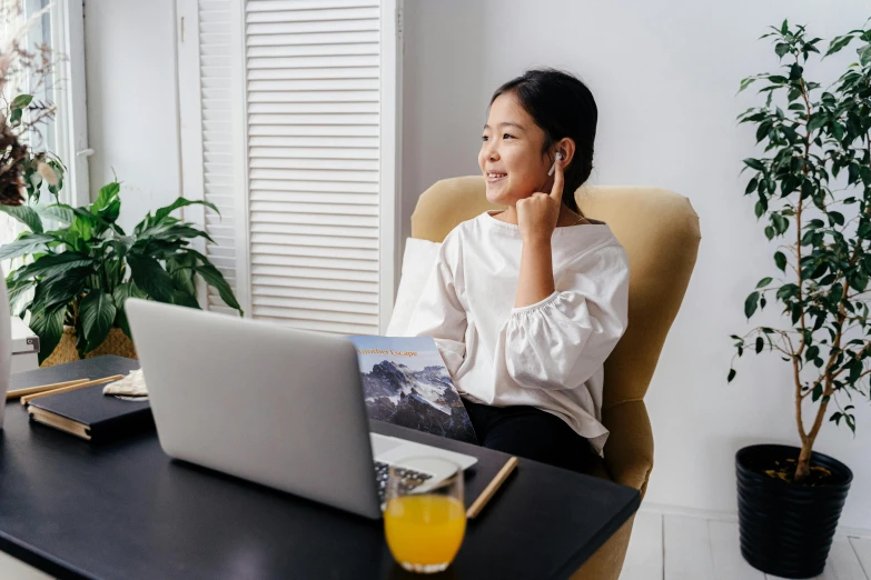 a woman sitting in a chair talking on a cell phone, inspired by Ruth Jên, pexels contest winner, happening, using a macbook, young asian girl, avatar image, modest