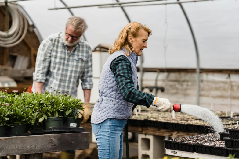 a man and woman watering plants in a greenhouse, profile image, holly bruce, central farm, pulling weeds out frantically