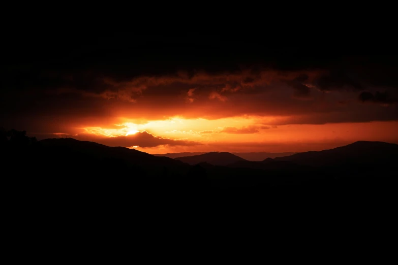 a black and red sky with a large cloud