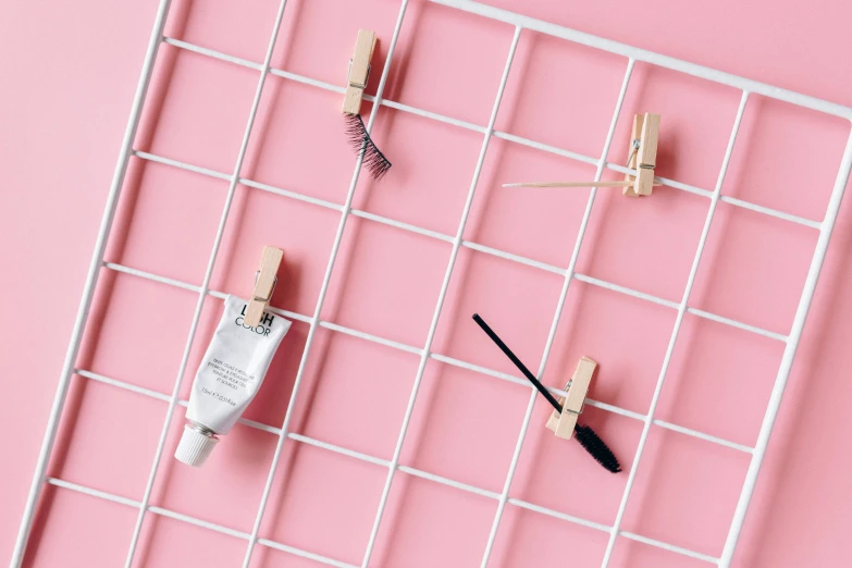 makeup products on a wire rack on a pink background, a picture, by Julia Pishtar, conceptual art, lattice, architect, white lashes, filling the frame