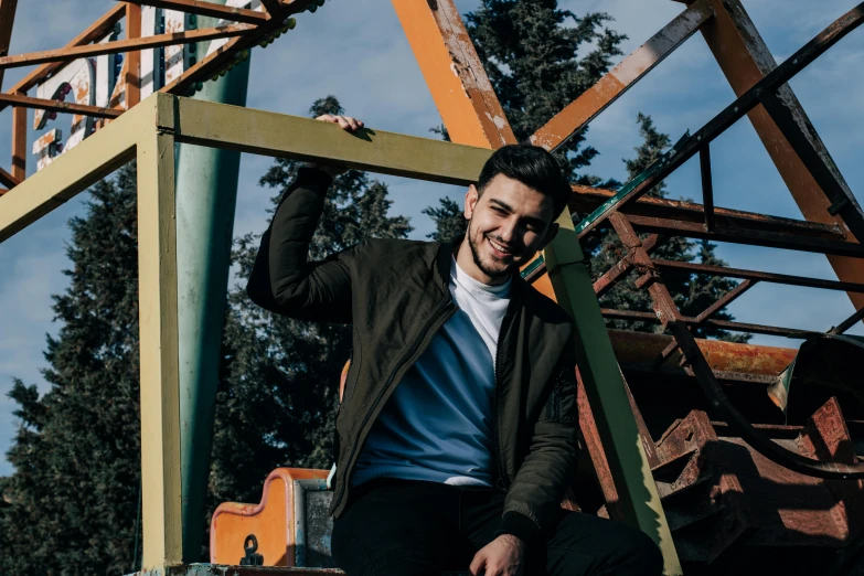 a man smiling on top of an abandoned carnival ride