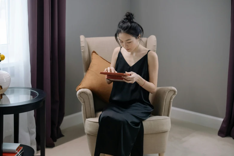 a woman sits in a chair reading a book