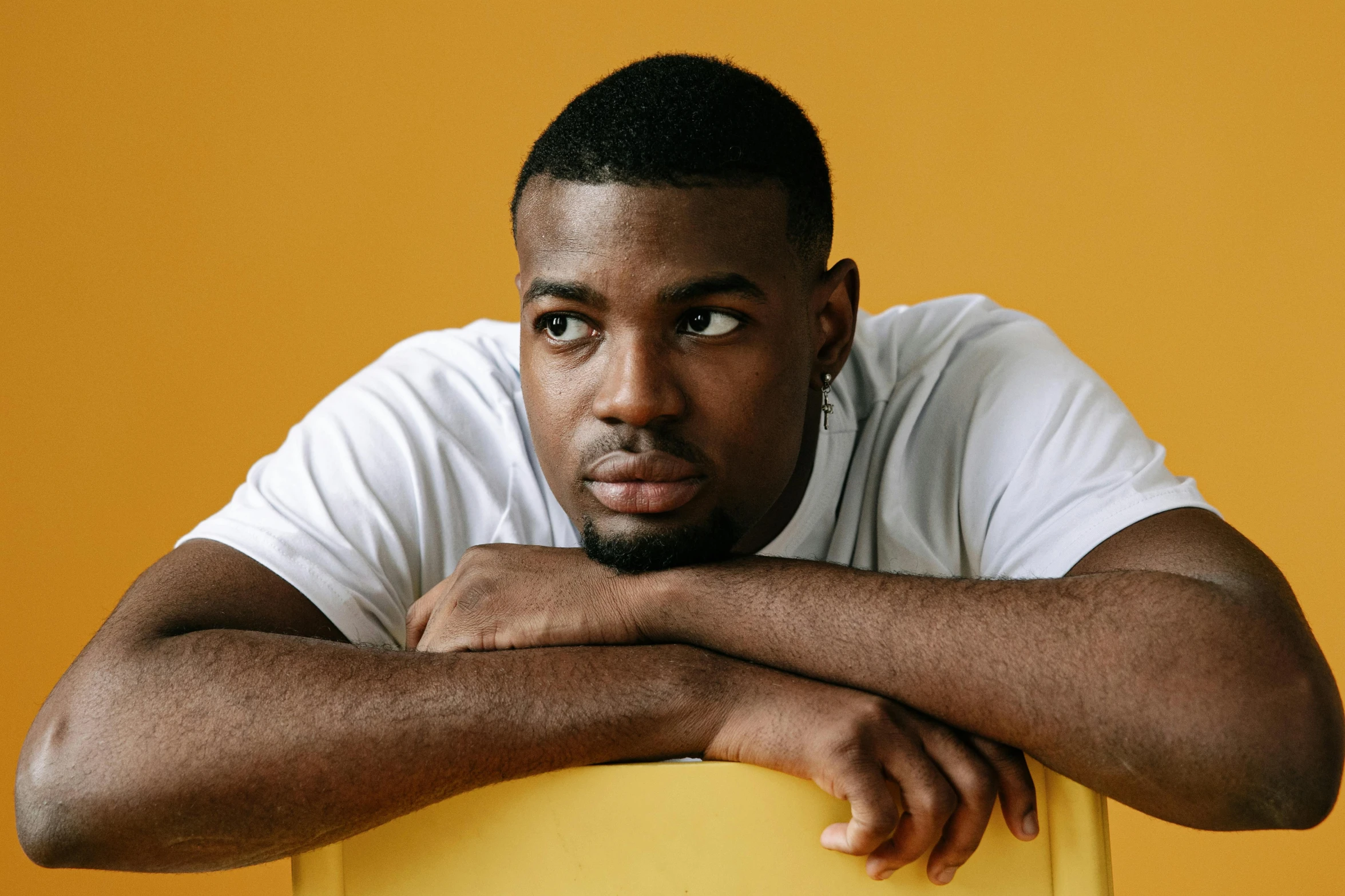 a man leans his elbows against a yellow box