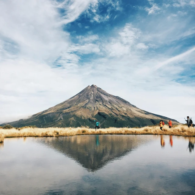 some people sitting by a mountain and the water