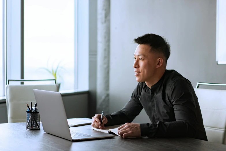 a man sitting at a table working on a laptop, inspired by Fei Danxu, pexels contest winner, happening, profile image, asian descent, lachlan bailey, no - text no - logo