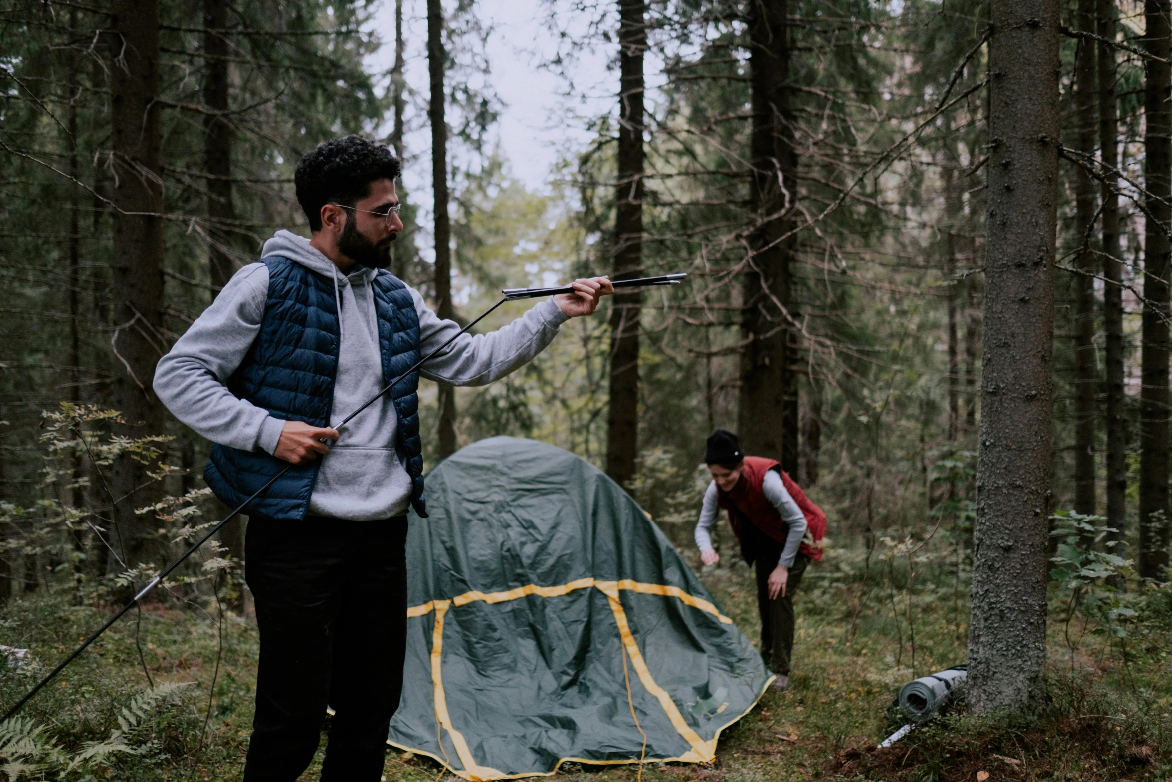 a man standing next to a tent in the woods, pexels contest winner, hurufiyya, action scene from the film, inspect in inventory image, college, enes dirig