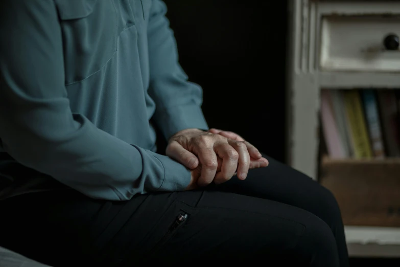 a close up of a person sitting on a bed, unsplash, hyperrealism, closed hands, sitting in a waiting room, paul barson, old woman