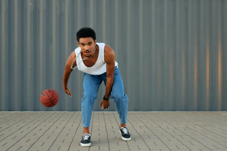 the young man is holding a basketball and ready to dribble it