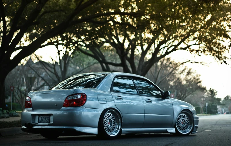 a silver car parked on the side of the road, a picture, by Austin English, unsplash, wrx golf, deep dish wheels, profile posing, late 2000’s