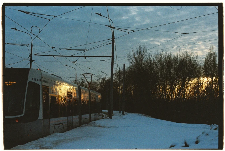 a train that is riding on the tracks by the snow