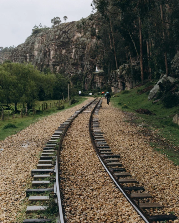 a couple of people walking down a train track, by Lucia Peka, unsplash contest winner, peruvian looking, rocky roads, similar to hagrid, photo on iphone