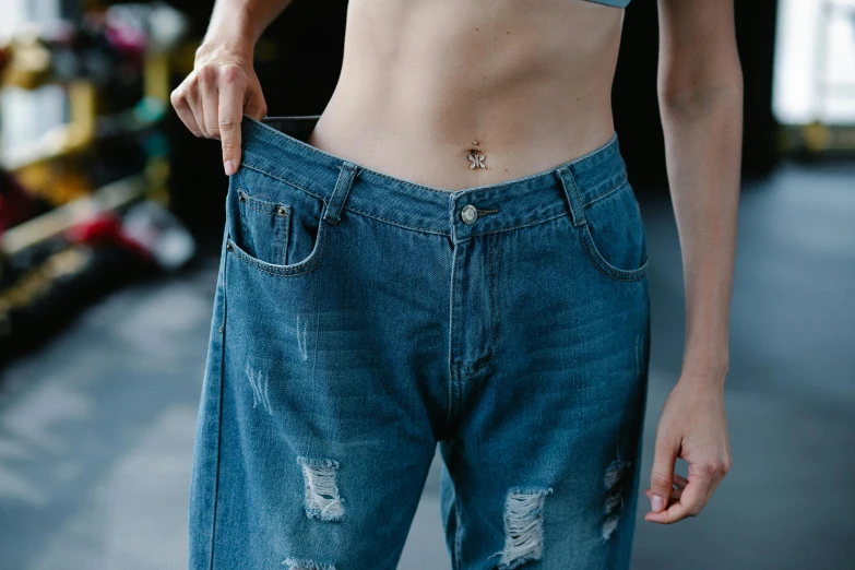 woman showing her ripped jeans and shirt