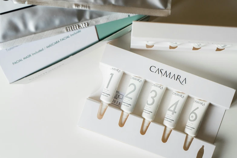 a couple of tubes sitting on top of a table, white box, skin blemishes, vanara, in a row