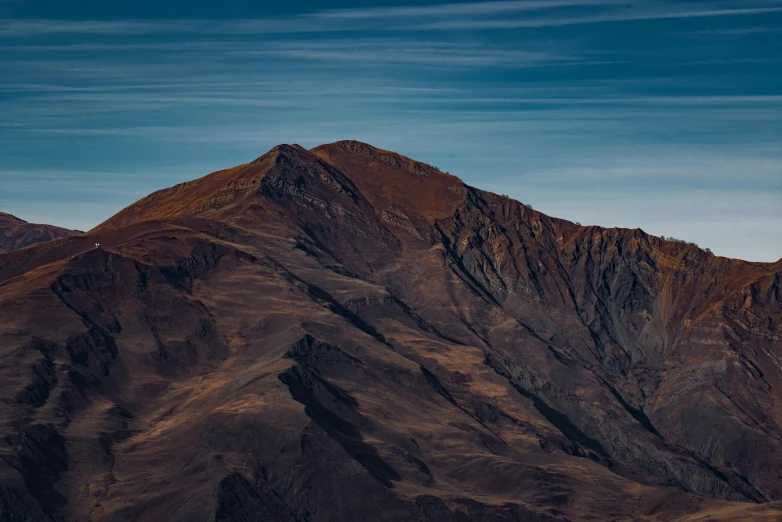 a plane is flying over a mountain with some tall grass