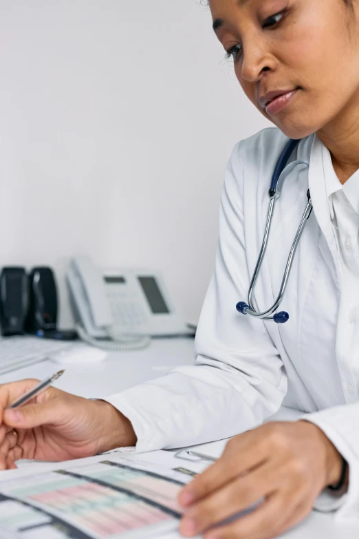 a woman with a stethoscope sitting at a desk, zoomed out, grey, thumbnail