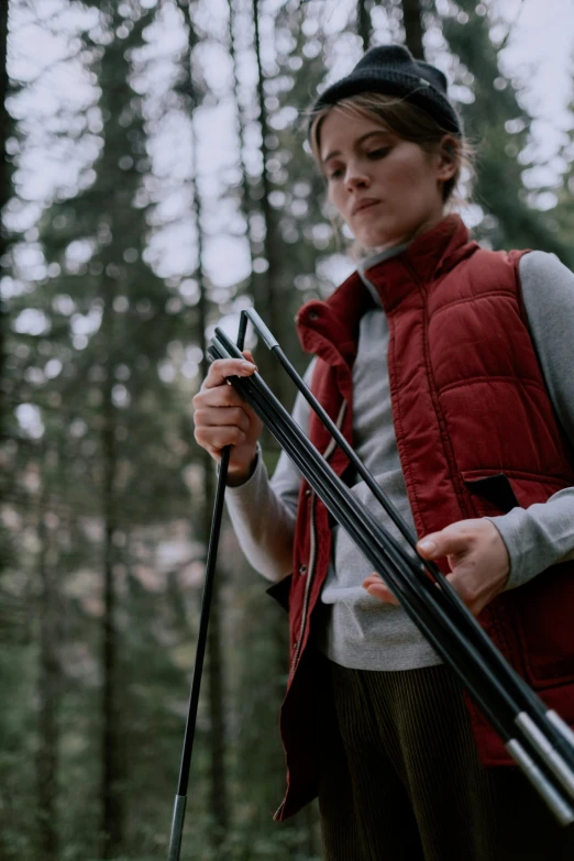 a woman in a red vest holding two skis, unsplash, renaissance, trekking in a forest, inspect in inventory image, thumbnail, starry