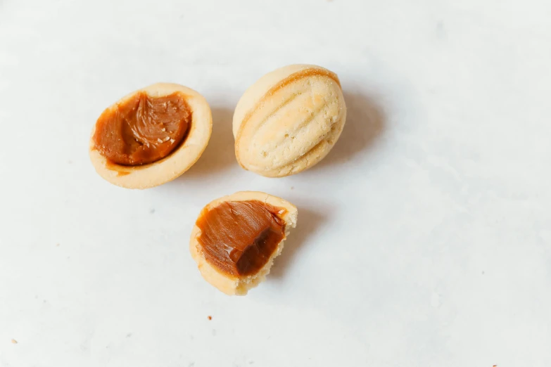 a couple of nuts sitting on top of a table, caramel, bao pham, 3 - piece, manuka