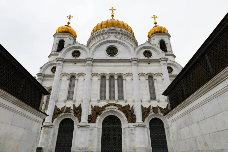 a large white building with two golden domes, church cathedral, on a gray background, square, documentary photo