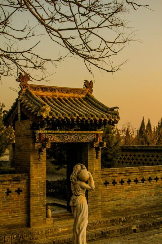 a statue of a woman standing in front of a gate, inspired by Zhang Zeduan, at the sunset, tiled roofs, celestial gardens, trending photo