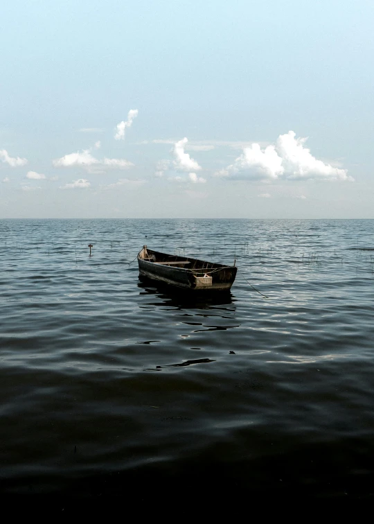 a small boat floating on top of a large body of water, by Eglon van der Neer, unsplash, in the styles of thomas eakins, black sea, slide show, a wooden