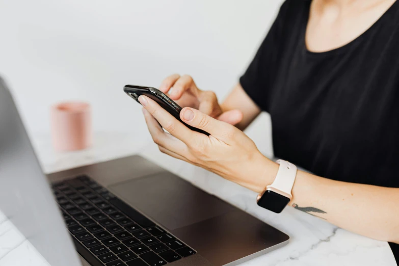 a woman sitting in front of a laptop holding a cell phone, trending on pexels, avatar image, background image, worksafe. instagram photo, profile image