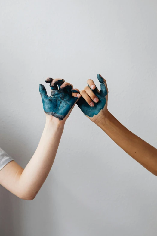 two people shaking hands with blue paint on their hands, by Matija Jama, trending on pexels, interactive art, on grey background, made of smooth black goo, lesbians, made of clay