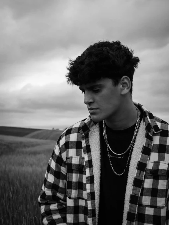 man wearing checkered jacket standing in front of black and white po