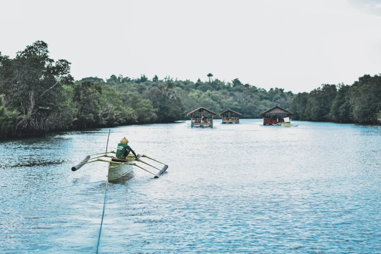 a person in a boat on a body of water, lagoon, in a row, manila, fan favorite