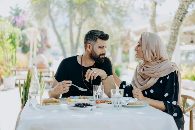 a woman and man are sharing food while sitting in a chair