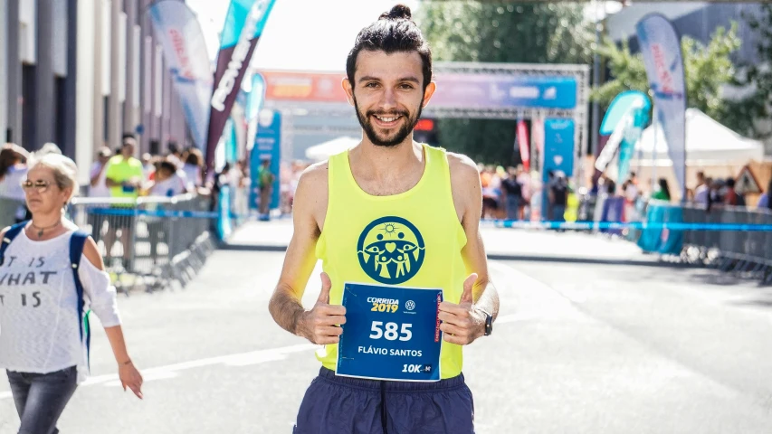 a man holding up a marathon plaque with people around him