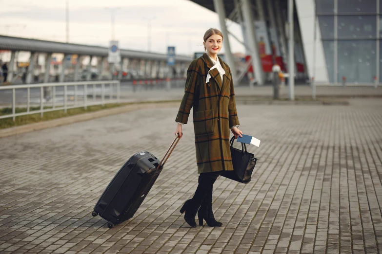 a woman is walking with her luggage at the airport, a portrait, by Emma Andijewska, shutterstock, wearing hunter coat, square, ukraine. professional photo, thumbnail