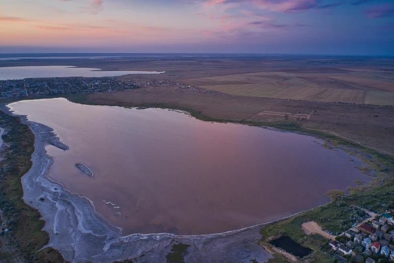 an aerial po of the land and the water at dusk