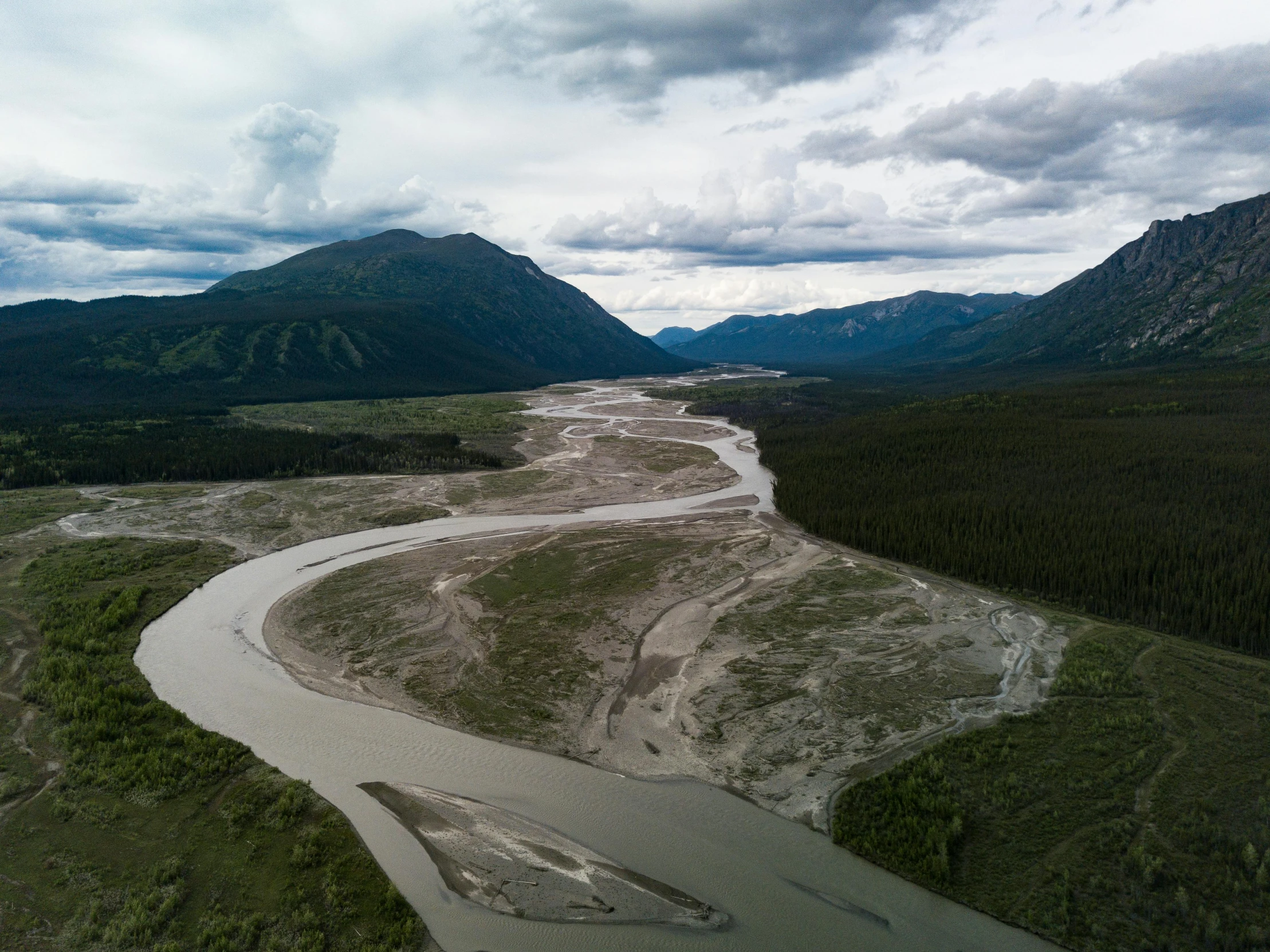 a view of a river running through a valley surrounded by hills