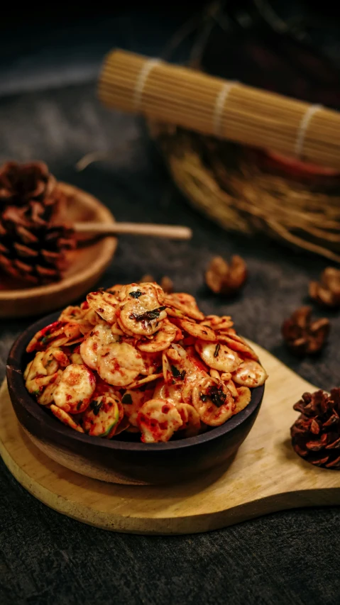 a bowl of food sitting on top of a wooden cutting board, by Basuki Abdullah, pexels, hurufiyya, crisps, festive, pine, prawn