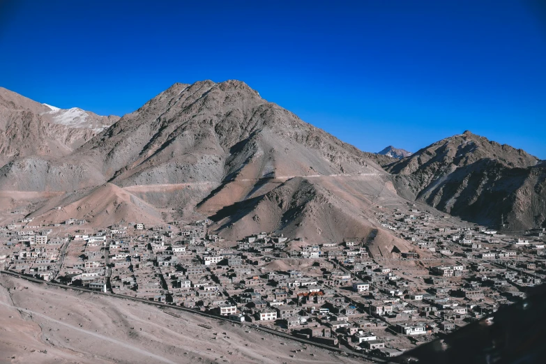 a town sitting between a mountain range in a desert
