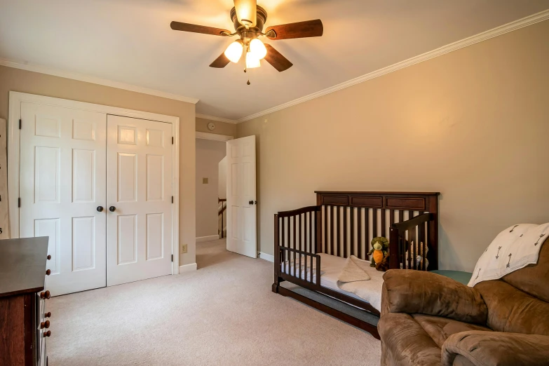 a baby room with a crib and couch and door