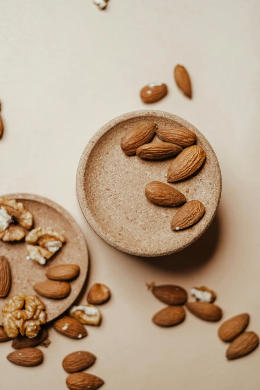 a wooden bowl filled with nuts on top of a table, trending on pexels, beige, thumbnail, skincare, having a snack