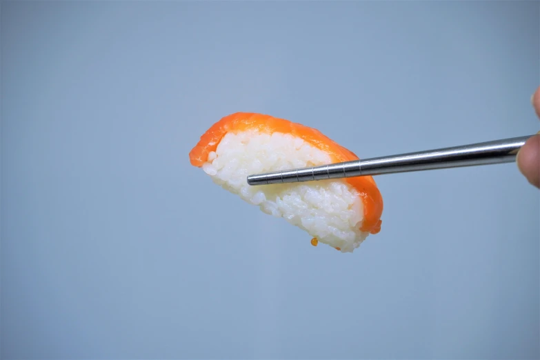 a person holding a pair of chopsticks over a piece of sushi, inspired by Koson Ohara, unsplash, sōsaku hanga, 3/4 view from below, orange: 0.5, white, small jaw