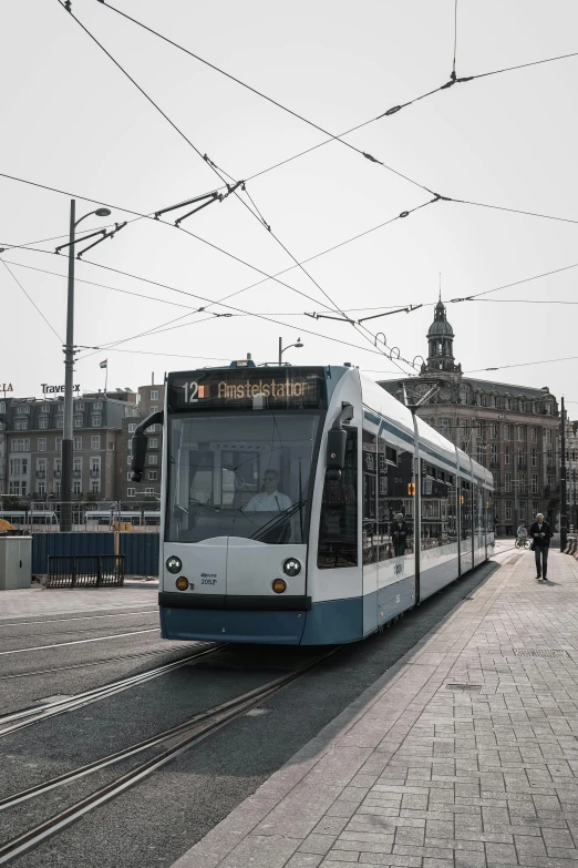 a large long train on a steel track, by Jacob Toorenvliet, pexels contest winner, happening, street tram, white and pale blue, square, advertising