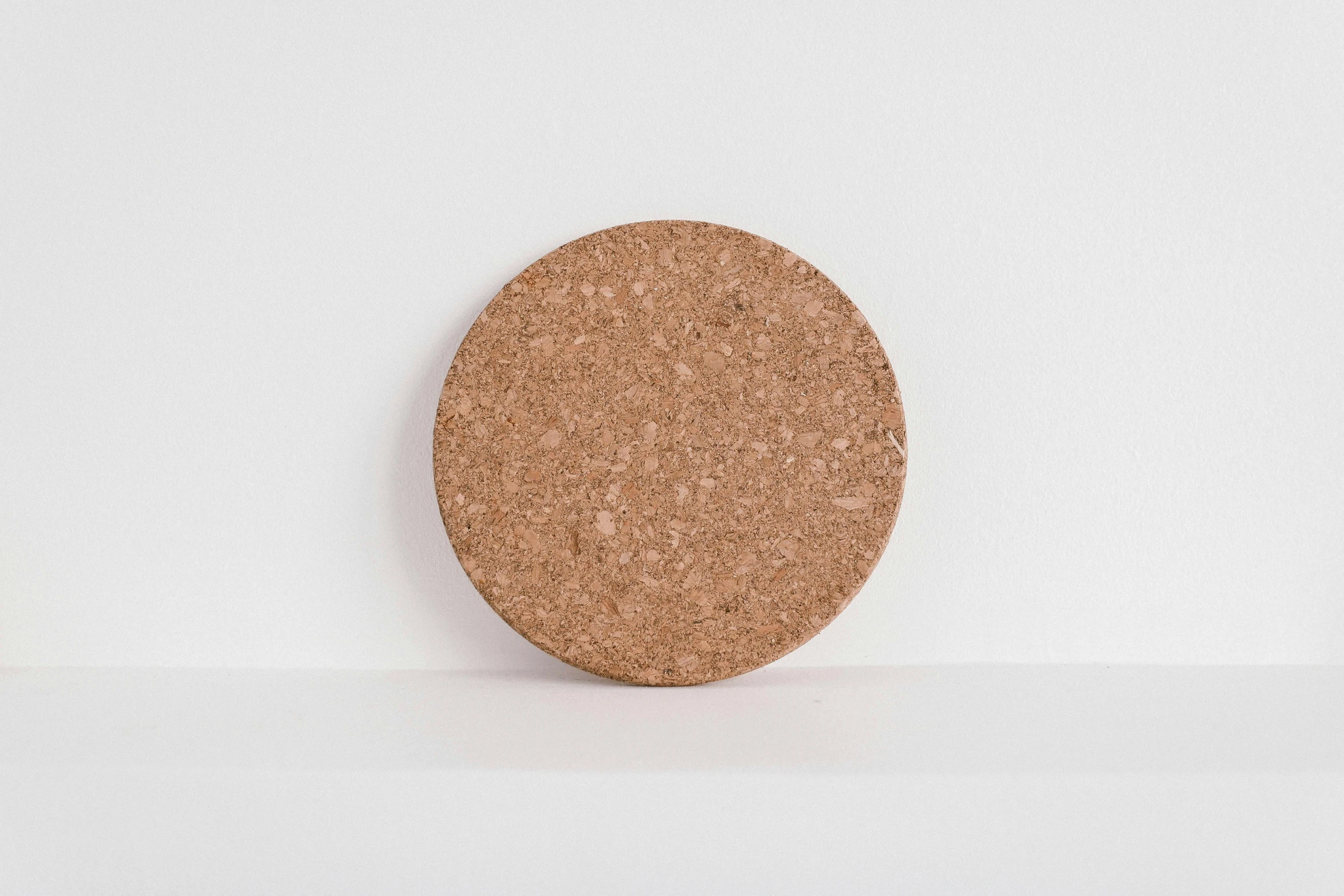 a cork coaster sitting on top of a white surface, by Nina Hamnett, very large, lush, light brown, at day