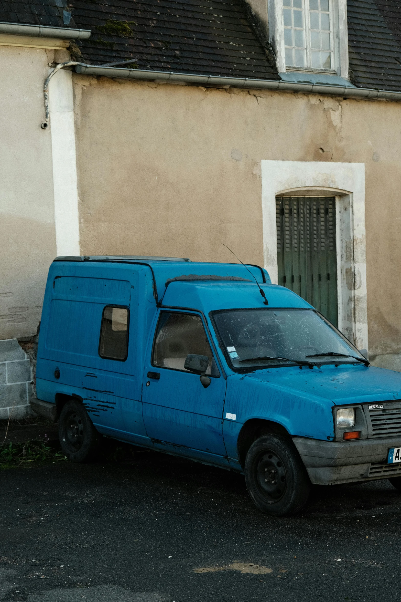 the van is painted blue and parked in the street