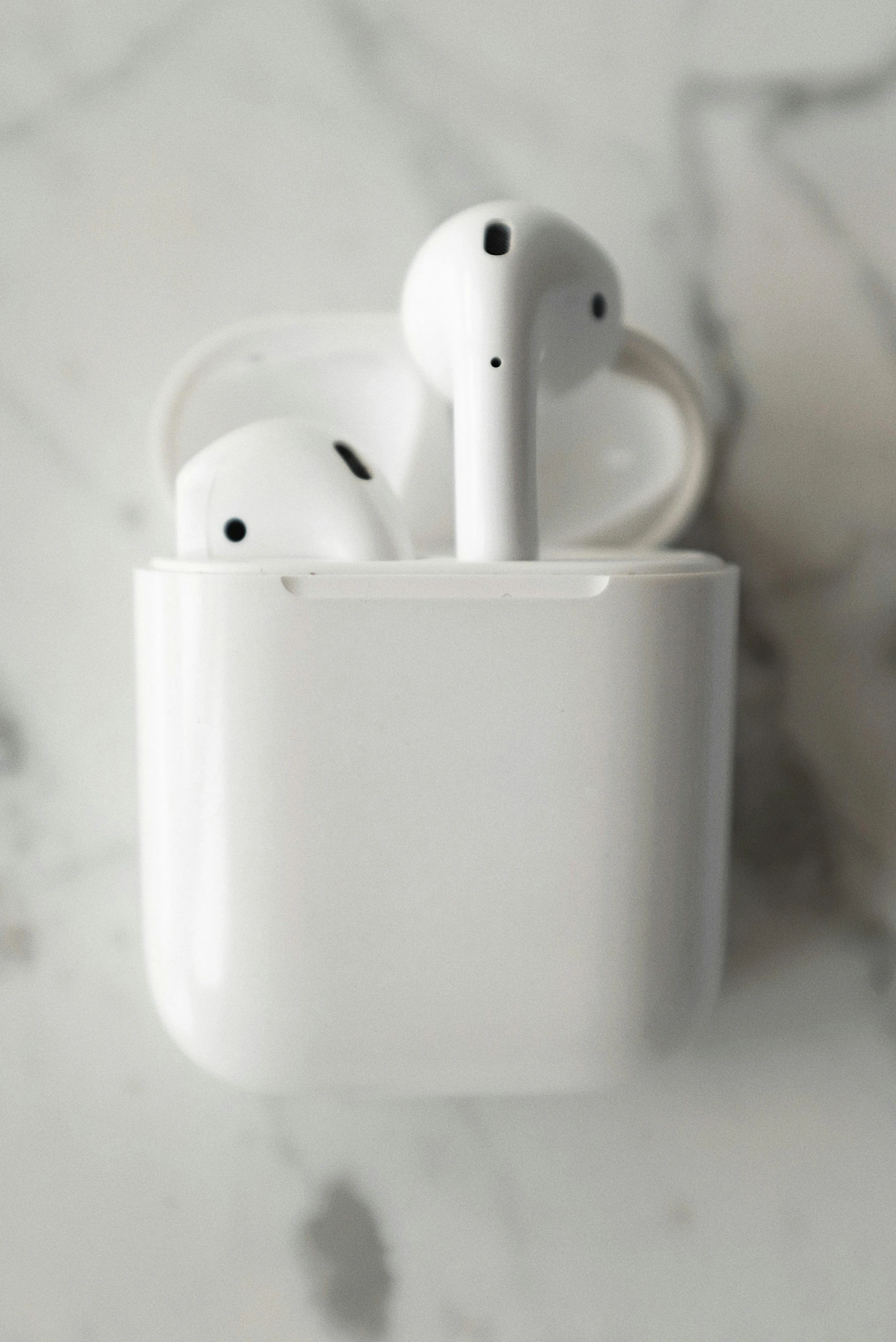 a pair of airpods sitting in a cup on a marble surface, by Carey Morris, trending on pexels, glossy white, airplane, apples, 12