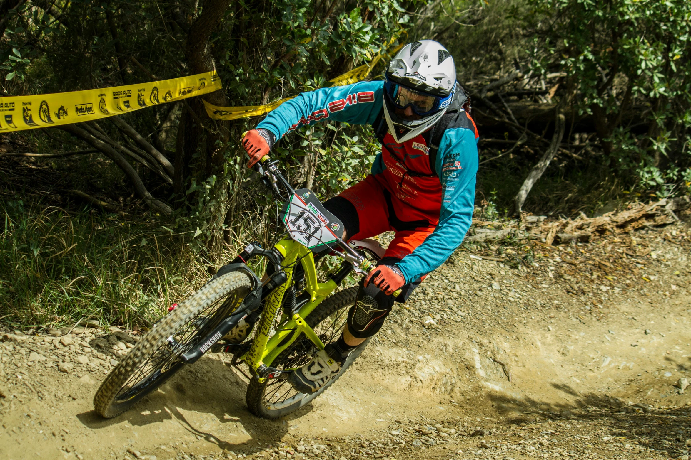 a man riding a bike down a dirt road, tournament, manuka, fullface, yellow