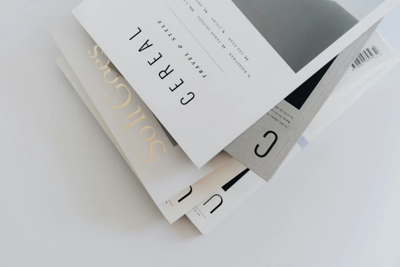 a stack of books sitting on top of each other, an album cover, trending on unsplash, private press, white grey color palette, thin gold details, behance lemanoosh, skincare